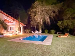 a swimming pool in the yard of a house at night at Sitio Haras Vitoria in Teresópolis