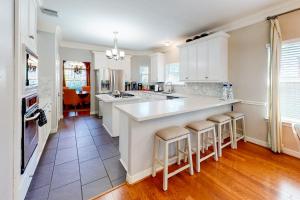 a kitchen with white cabinets and a large island with bar stools at Family-Friendly City Living in Houston