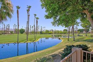 een golfbaan met palmbomen en een vijver bij VB623 - Suite Sycamore in Palm Desert