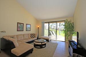 uma sala de estar com um sofá e uma televisão em VS555 - Palm Views em Palm Desert