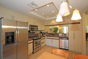 uma cozinha com um frigorífico de aço inoxidável e uma mesa em VS555 - Palm Views em Palm Desert