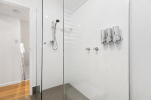 a shower with a glass door in a bathroom at Jandar Retreat Maleny in Maleny