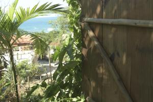 a wooden fence with a plant next to it at Canto de Paz Trindade Hospedagem in Trindade