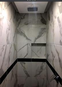 カンクンにあるGreen Loftsの大理石の壁のバスルーム(シャンデリア付きのシャワー付)