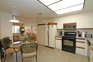 uma cozinha com um fogão e uma mesa com cadeiras em VY236 - Sunny Palm em Palm Desert