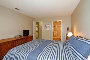 um quarto com uma cama com riscas azuis e brancas em VY236 - Sunny Palm em Palm Desert