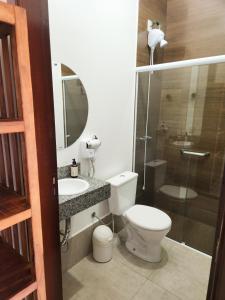 y baño con aseo, lavabo y ducha. en Pousada Luz de Candeia, en São João Batista do Glória