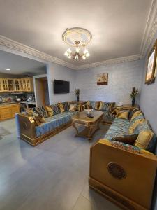 una gran sala de estar con sofás y una mesa. en maison alhaj en Tánger