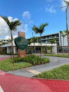 ein Schild vor einem Gebäude mit Palmen in der Unterkunft Mana Beach Experience B 114, Porto de Galinhas in Porto De Galinhas