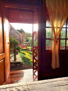 uma porta aberta com vista para um jardim em Paraiso Orquideario em Baños