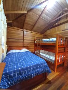 a bedroom with two bunk beds in a cabin at Paraiso Orquideario in Baños