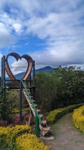 a heart sculpture sitting on a bench in a garden at Paraiso Orquideario in Baños