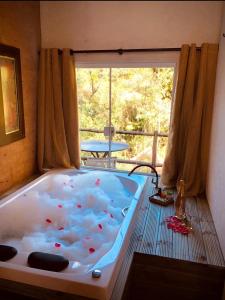 bañera grande en una habitación con ventana en Middle House, en Campos do Jordão