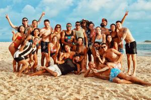 a group of people posing for a picture on the beach at Iduna Hostel in Pipa