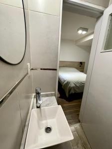 Patagonia Apartment في تريليو: حمام مع مغسلة وسرير في الغرفة