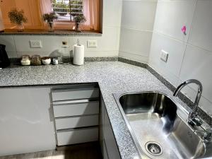 a kitchen with a sink and a counter top at Patagonia Apartment in Trelew +46 photos