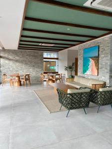 ein Wohnzimmer mit Tischen und Stühlen und einer Steinmauer in der Unterkunft Mana Beach Experience B 114, Porto de Galinhas in Porto De Galinhas + 23 Fotos