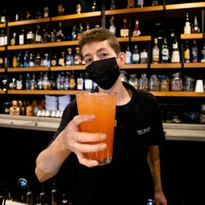 a man wearing a mask holding a drink at 653 Hotel in San Luis Río Colorado