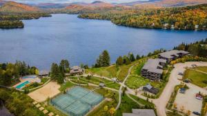 an aerial view of a house with a tennis court on a lake at Deluxe Suite - View on Lake & 6 Min from Tremblant Versant Nord in Lac-Superieur