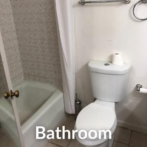 a bathroom with a white toilet and a bath tub at Nights Inn - Richfield in Richfield