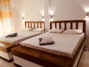 2 Einzelbetten in einem Zimmer mit weißen Wänden in der Unterkunft Wild Eagle Safari Resort in Udawalawe