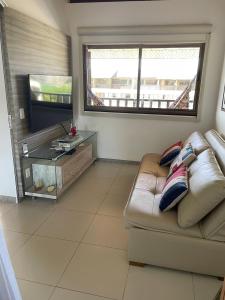 a living room with a couch and a flat screen tv at Flat Duplex - Muro Alto Malawí in Porto De Galinhas