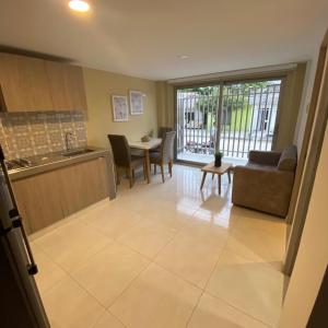 a kitchen and living room with a couch and a table at Aparta Suites Balcones de la Sierra in Fundación