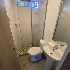 W łazience znajduje się toaleta, umywalka i prysznic. w obiekcie Aparta Suites Balcones de la Sierra w mieście Fundación