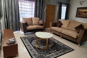 Sala de estar con 2 sofás y mesa de centro en Homestay FourSeasons @ Bandar Baru Bangi, en Bandar Baru Bangi
