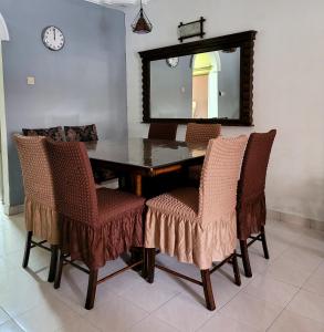 a dining room table with chairs and a mirror at Homestay FourSeasons @ Bandar Baru Bangi in Bandar Baru Bangi