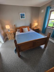 a bedroom with a large wooden bed with blue curtains at Old Killarney in Killarney