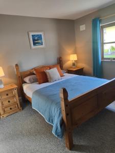 sypialnia z dużym drewnianym łóżkiem z niebieską pościelą w obiekcie Old Killarney w Killarney