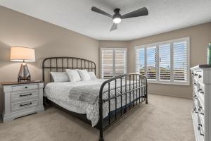 a bedroom with a bed and a ceiling fan at Newly Updated St. Pete 2-BR Condo on Isla Del Sol in St Petersburg +14 photos