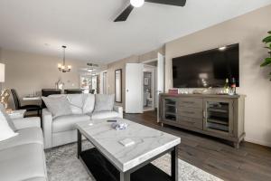 a living room with a white couch and a tv at Newly Updated St. Pete 2-BR Condo on Isla Del Sol in St Petersburg