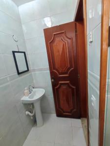 a bathroom with a wooden door and a sink at Apartamento completo no centro in Teresópolis