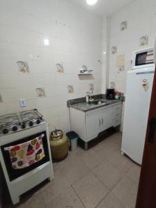 uma cozinha com um fogão e um frigorífico branco em Apartamento completo no centro em Teresópolis