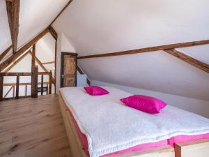a bedroom with a bed with pink pillows on it at Comfy holiday home in Roes with terrace in Roes