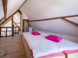 a bedroom with a bed with pink pillows on it at Himmelshöh Loft Retreat in Roes