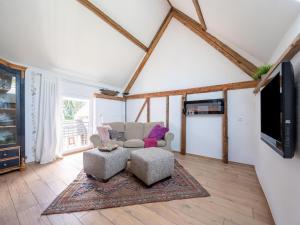 ein Wohnzimmer mit einem Sofa und einem TV in der Unterkunft Comfy holiday home in Roes with terrace in Roes