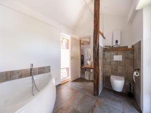 a bathroom with a tub and a toilet and a sink at Himmelshöh Loft Retreat in Roes +32 photos