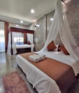 um quarto com 2 camas e lençóis brancos em บ้านพักบุหงา199 อ สรรพยา em Sanphaya