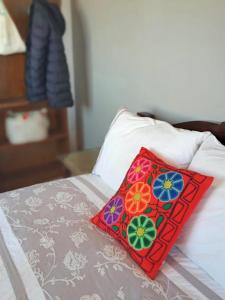 a red pillow with flowers on a bed at Rodando x Mendoza in Guaymallen