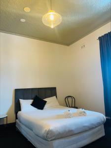 1 dormitorio con 1 cama grande y cortina azul en Belmore Hotel Scone, en Scone