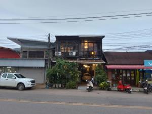 une voiture blanche garée devant un bâtiment dans l'établissement ทุ่งยั้งเฮ้าส์, à Uttaradit