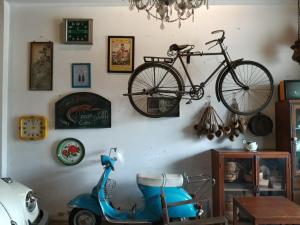 a bike hanging on a wall next to a scooter at ทุ่งยั้งเฮ้าส์ in Uttaradit