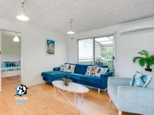un soggiorno con un divano blu e un tavolo di Retro Groovy Pad Pt Elliot a Port Elliot