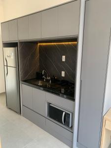 een keuken met een wastafel en een magnetron bij 502 | Studio exclusivo na Rua Oscar Freire Novo in Sao Paulo