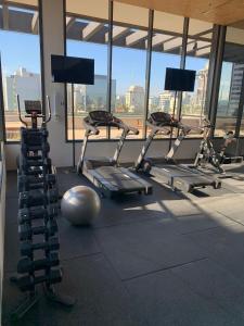 een fitnessruimte met cardio-apparatuur in een gebouw met ramen bij 502 | Studio exclusivo na Rua Oscar Freire Novo in Sao Paulo
