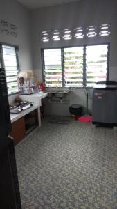 Zimmer mit einer Küche mit 2 Fenstern und einem Schreibtisch. in der Unterkunft IPOH Homestay in Ipoh