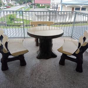 una mesa y dos sillas sentadas junto a una mesa y sillas en IPOH Homestay, en Ipoh